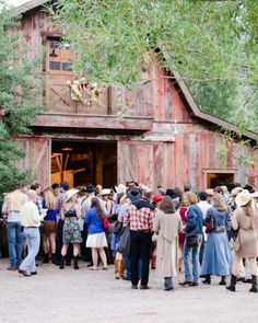 a group of people standing in front of a barn