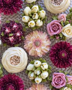 many different types of flowers arranged on a wicker surface