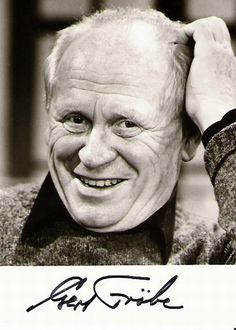 black and white photograph of an older man smiling with his hands on his head while wearing a bow tie