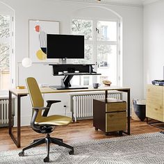 a room with a desk, chair and computer monitor