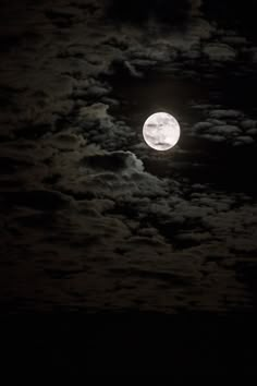 the full moon shines brightly in the night sky with clouds and dark blue skies