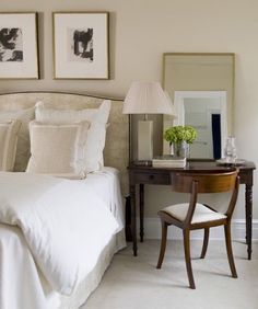 a bedroom with two framed pictures on the wall