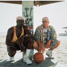 two men sitting next to each other holding basketballs