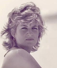 a black and white photo of a woman with wavy hair looking off to the side