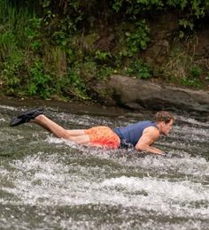 a man is laying on his stomach in the water