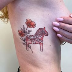 a woman's stomach with a tattoo of a horse and flowers on the side