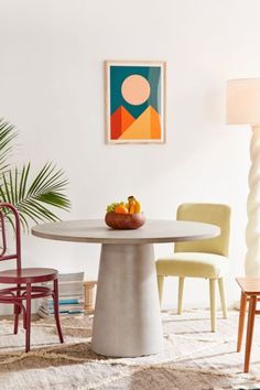 a white table and chairs in a room with a painting on the wall behind it