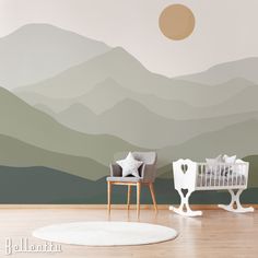 a baby's room with mountains painted on the wall and two rocking chairs in front