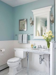 a bathroom with blue walls and white fixtures