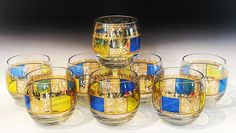 there are many glasses that have different designs on them, and one is blue and yellow