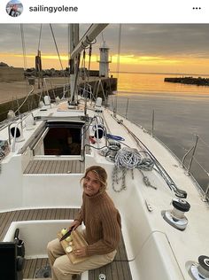 a woman sitting on top of a boat next to the ocean