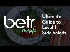 a white plate topped with vegetables and meat next to a fork on top of a table