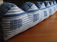 three blue and white striped pillows sitting on top of a wooden table