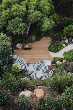 A Mediterranean-inspired garden with a wooden patio and zen-like gravel patterns surrounded by diverse Mediterranean plants and trees. Garden Ideas Simple, Modern Mediterranean Garden, Herb Garden Ideas, Zen Vibes, Wooden Patio, Garden Layout Ideas