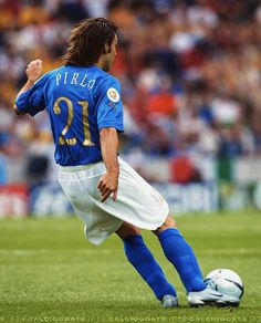 a man kicking a soccer ball on top of a field