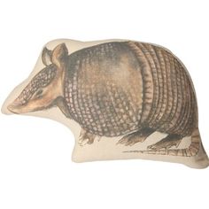 an armadile shaped pillow is shown on a white background, with the armadile painted on it's side