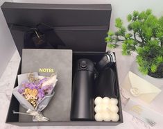 a black box with some flowers and candles in it