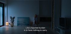 a woman standing in a living room next to a window with the words life's heavenest burden is to have nothing to carry