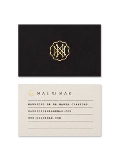 two business cards with gold foil on black and white paper, one has a monogrammed