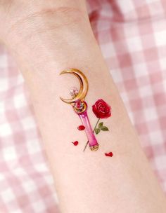 a woman's arm with a rose and crescent tattoo on it