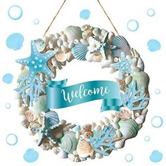 a welcome sign hanging from the side of a wreath filled with seashells and starfish