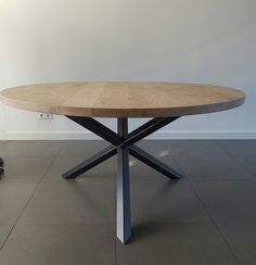 a wooden table sitting on top of a tile floor next to a black and white wall