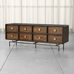 a large wooden dresser sitting on top of a tiled floor next to a white curtain