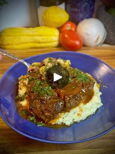 a blue plate topped with mashed potatoes and meat