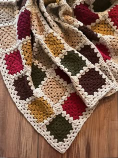 a crocheted blanket sitting on top of a wooden floor