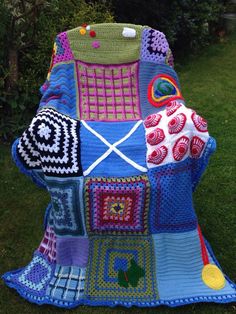 a crocheted blanket is sitting on the grass