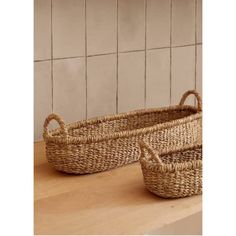 two woven baskets sitting on top of a wooden counter