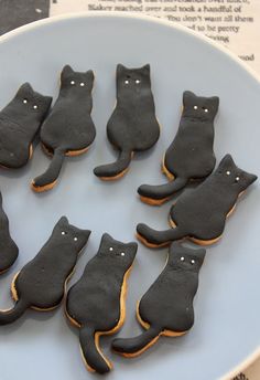 a plate that has some cookies in the shape of cats on it