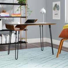 a computer desk with a laptop on top of it in front of a book shelf