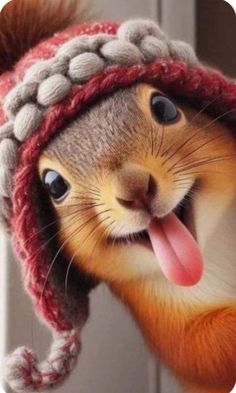 a squirrel wearing a knitted hat with its tongue hanging out and sticking it's tongue out