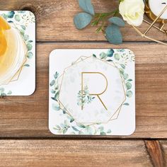 two coasters with the letter r on them next to some flowers and candles in vases