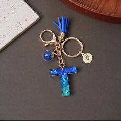 a keychain with a blue tassel hanging from it's side on a table