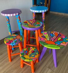 three brightly colored stools and two small tables