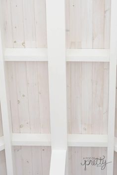 two white bookshelves with wooden boards on them