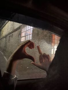 a person holding their hand out the window in the rain