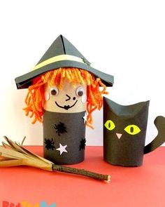 an orange haired cat sitting next to a paper cup with a witches hat on it