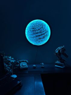 a desk with a phone and a blue light in the dark room next to it