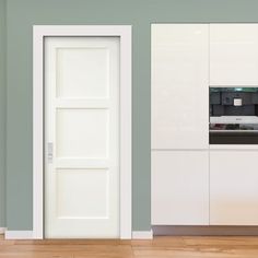 an open door to a kitchen with white cupboards and drawers on the wall in front of it