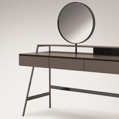 a mirror sitting on top of a wooden desk next to a black drawer and shelf