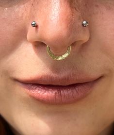 a woman with piercings on her nose and nose ring in the shape of a crescent