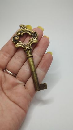 a person is holding an antique key in their hand