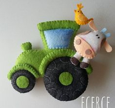 a green toy tractor with a giraffe on the front and a cow on the back