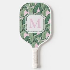 a pink and green tropical print paddle with the letter m on it