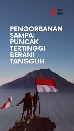 two people standing on top of a mountain with a flag