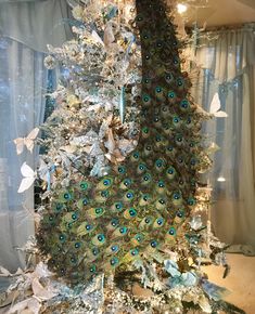 a christmas tree decorated with peacocks and butterflies