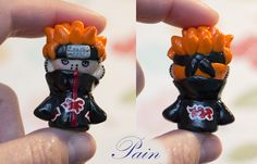 two small figurines in the shape of people with orange hair and black clothes